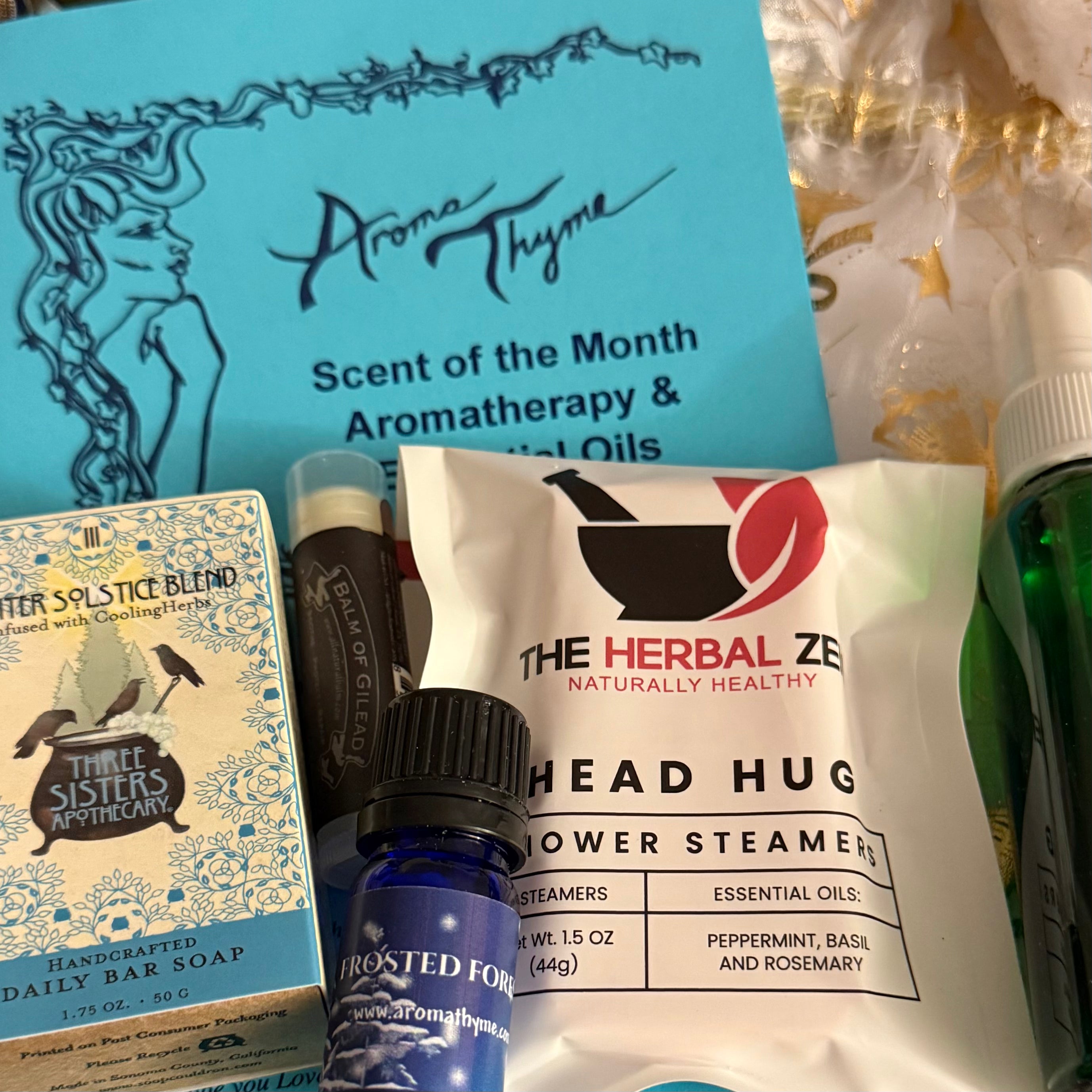 Collection of Aroma Thyme Scent of the Month Club and The Herbal Zen products including a bottle, soap, and steamers.